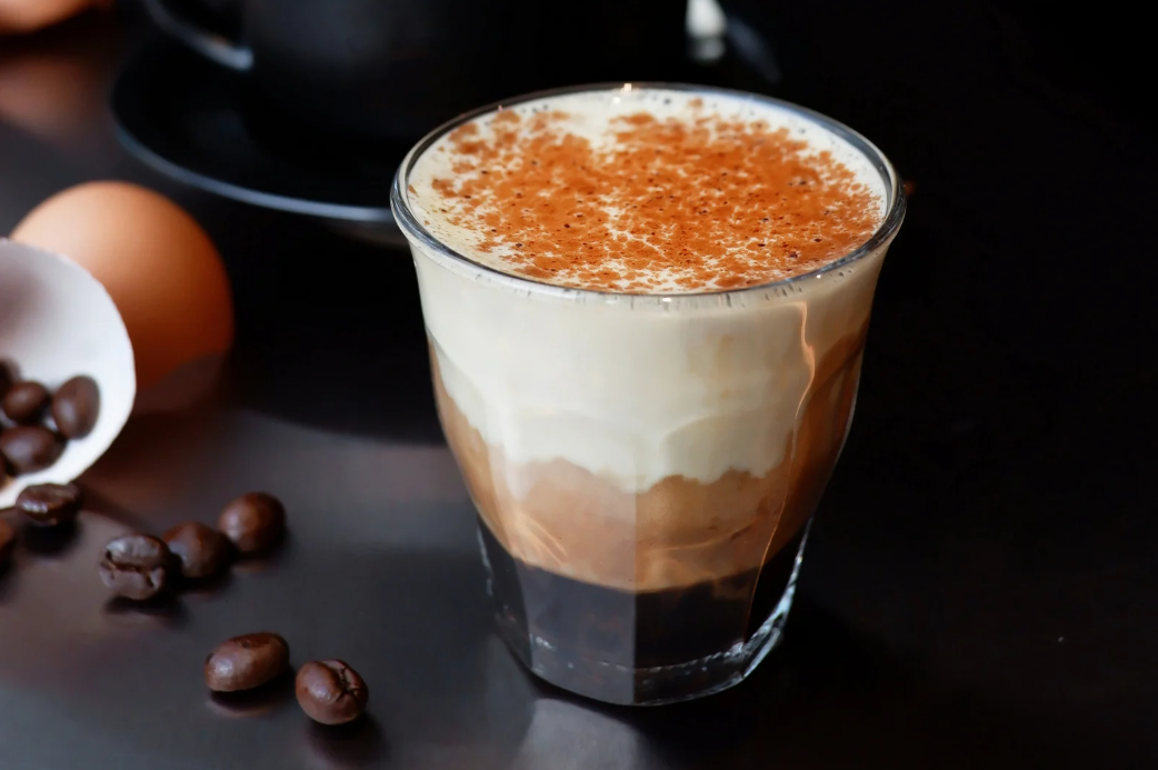 A chilled glass of creamy yogurt coffee swirls with bold espresso and a hint of sweetness.